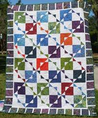 A colorful quilt on a white surface

Description automatically generated