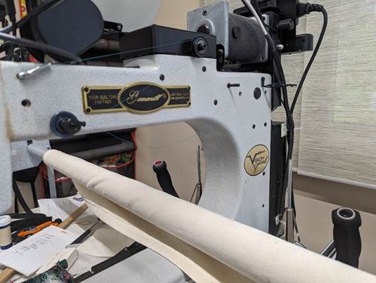 A sewing machine with a roll of fabric

Description automatically generated