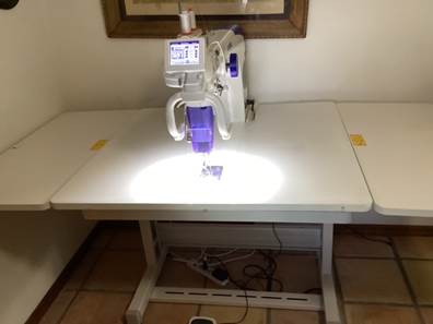 A sewing machine on a table

Description automatically generated